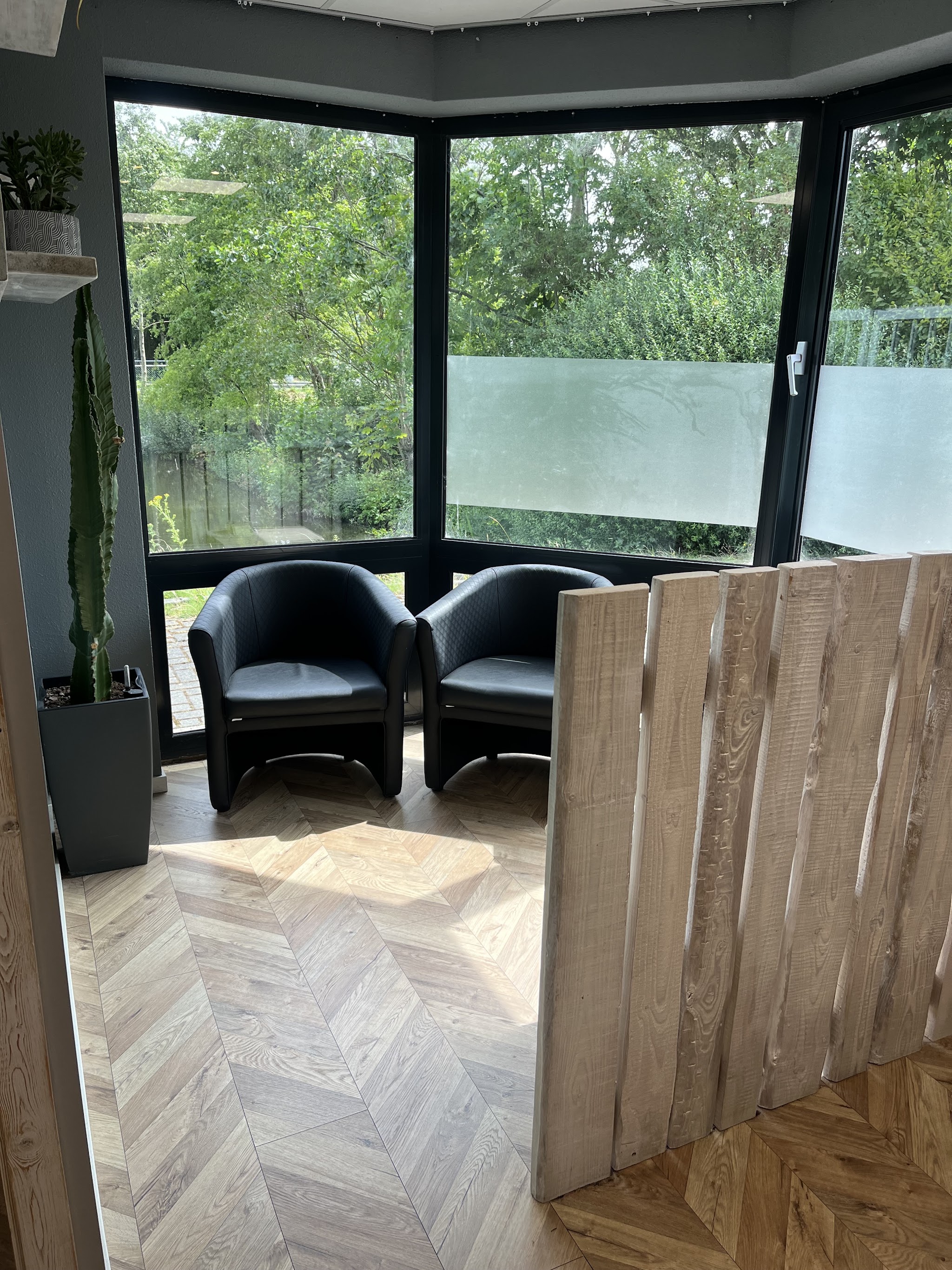 Twee zwarte wachtstoelen bij het hoekraam met uitzicht op groen